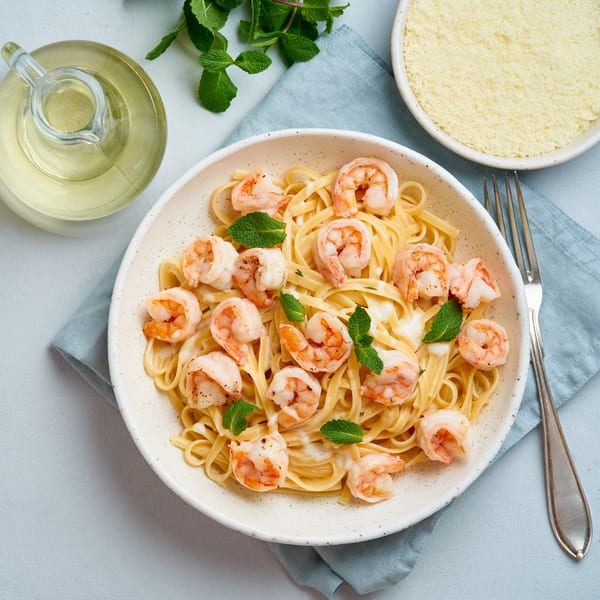 Shrimp scampi with linguine pasta, cream sauce, and fresh mint, served with olive oil and parmesan.