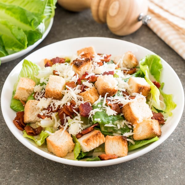 Caesar salad with crisp romaine lettuce, crunchy croutons, bacon bits, and grated Parmesan cheese.